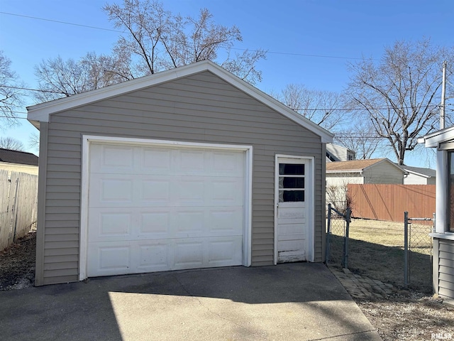 detached garage featuring driveway and fence