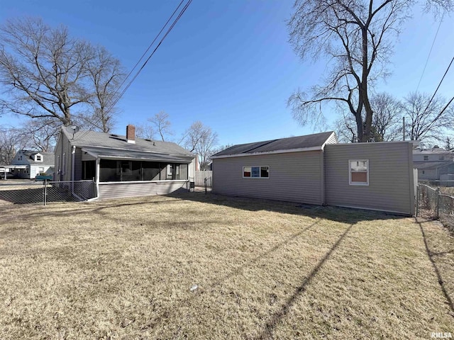 back of house with a lawn, a fenced backyard, and a sunroom