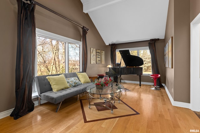 sitting room with beam ceiling, wood finished floors, baseboards, and high vaulted ceiling