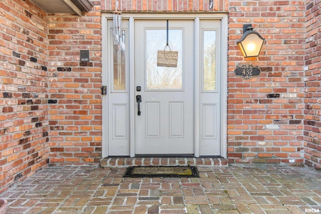 view of exterior entry with brick siding