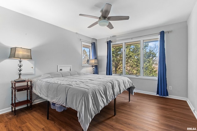 bedroom featuring ceiling fan, baseboards, and wood finished floors