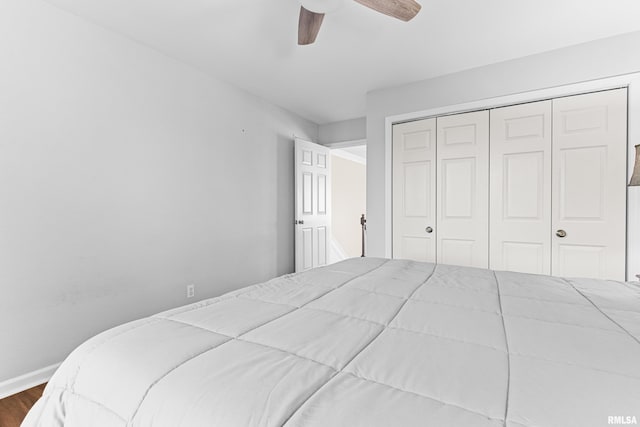 bedroom featuring dark wood-style floors, baseboards, a ceiling fan, and a closet