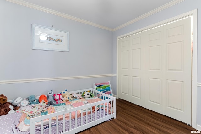 bedroom with crown molding, wood finished floors, and a closet