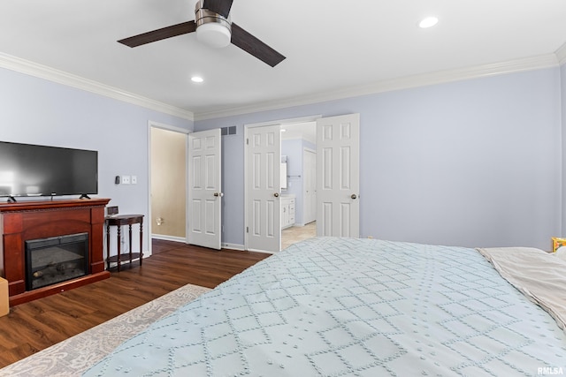 bedroom featuring a glass covered fireplace, visible vents, wood finished floors, and crown molding