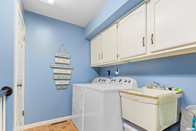 laundry area featuring visible vents, baseboards, cabinet space, independent washer and dryer, and a sink