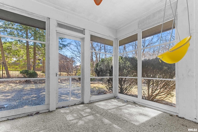 unfurnished sunroom featuring a ceiling fan