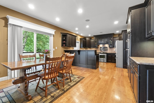 dining room with baseboards, light wood finished floors, and recessed lighting