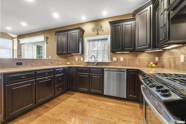 kitchen featuring recessed lighting, a sink, appliances with stainless steel finishes, backsplash, and light wood finished floors