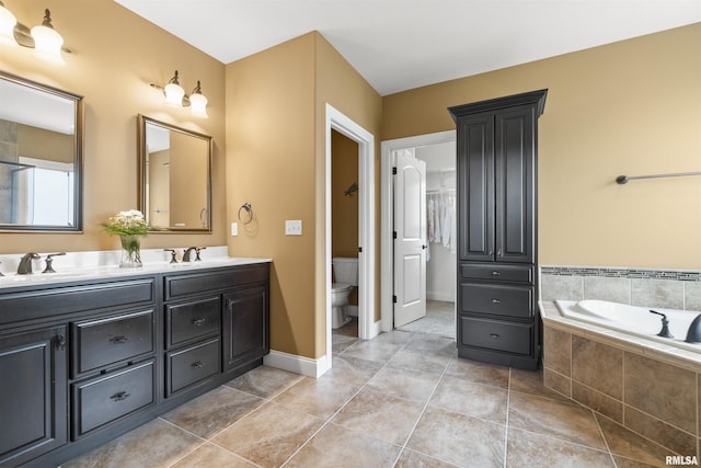 full bathroom with double vanity, a sink, toilet, and tile patterned floors