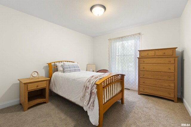 bedroom with light carpet, baseboards, and a closet