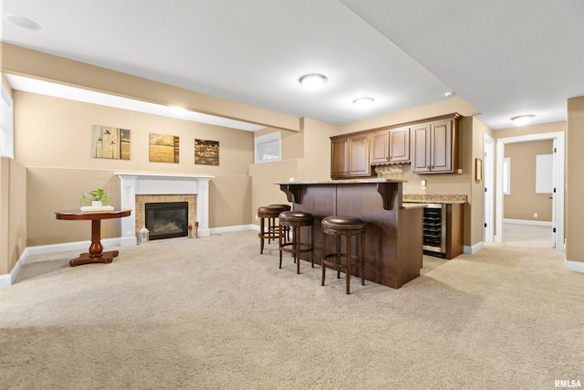 kitchen with beverage cooler, baseboards, a sink, and dark brown cabinets