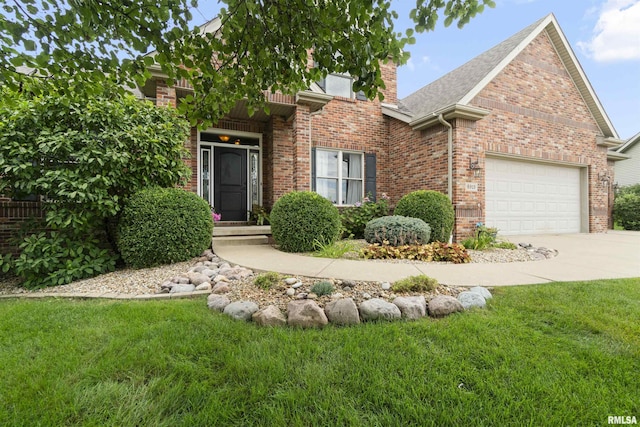 view of front of property featuring a front yard, brick siding, driveway, and an attached garage