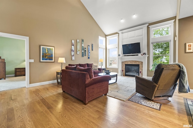 living room featuring visible vents, baseboards, stairway, a high ceiling, and light wood-type flooring