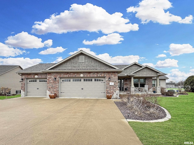 view of front of property with brick siding, a front lawn, a porch, a garage, and driveway