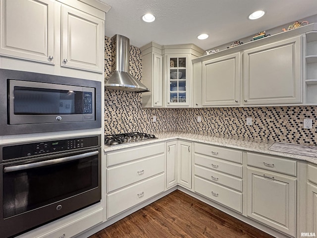 kitchen with open shelves, backsplash, dark wood-style floors, appliances with stainless steel finishes, and wall chimney range hood