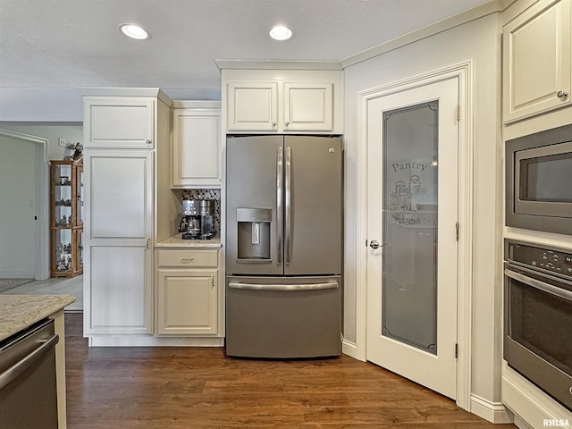 kitchen featuring dark wood finished floors, recessed lighting, stainless steel appliances, and light stone counters