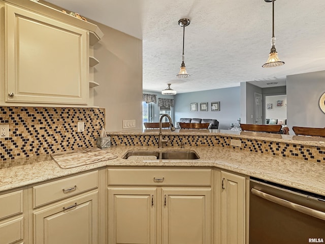 kitchen with cream cabinetry, a sink, backsplash, stainless steel dishwasher, and open floor plan