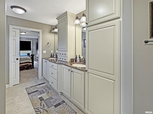 ensuite bathroom featuring double vanity, ensuite bathroom, and a sink