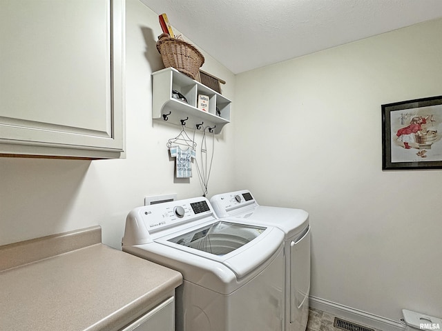 laundry room with washer and clothes dryer, visible vents, cabinet space, and baseboards