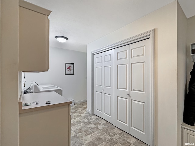 laundry area featuring baseboards, cabinet space, and washer / dryer