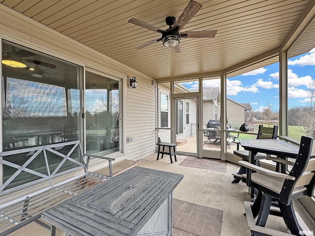 sunroom with wood ceiling and a ceiling fan