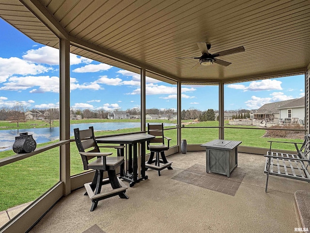 sunroom / solarium featuring a ceiling fan and a water view