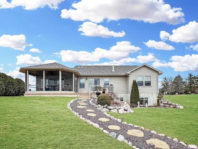 back of property with a lawn and a sunroom