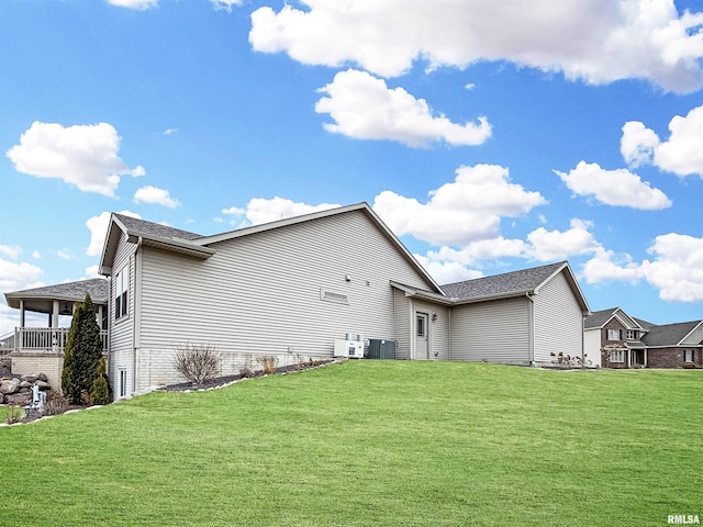 back of property featuring cooling unit and a lawn