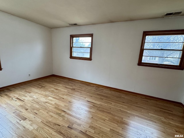 unfurnished room featuring visible vents and wood finished floors