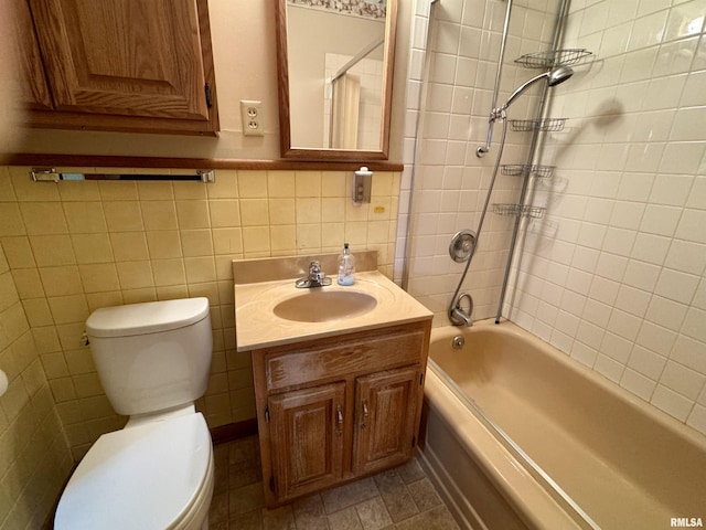 full bathroom featuring bathtub / shower combination, vanity, toilet, and tile walls