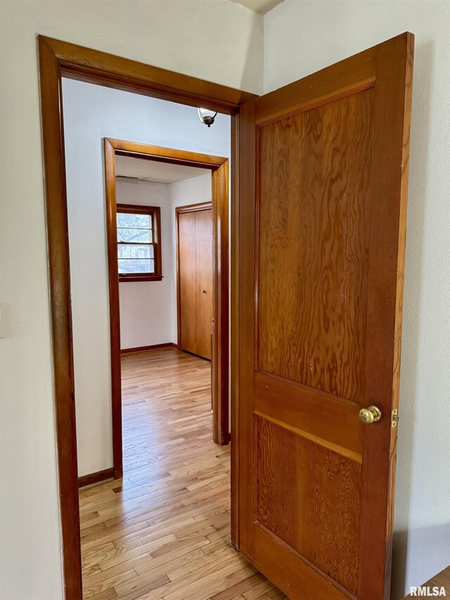 hall with light wood finished floors and baseboards