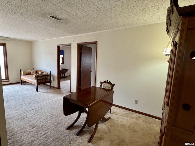 home office featuring carpet floors, visible vents, ornamental molding, and baseboards