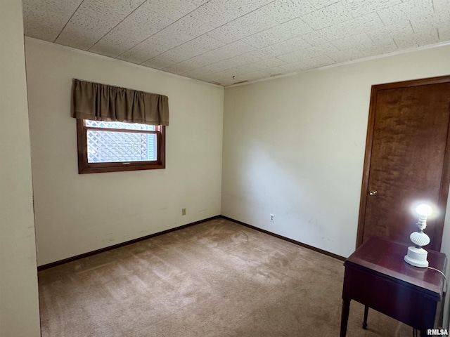 unfurnished room with carpet and baseboards