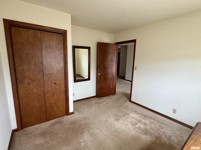 unfurnished bedroom featuring carpet floors, baseboards, and a closet