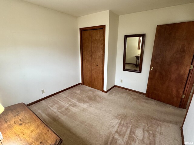 unfurnished bedroom with carpet floors, a closet, and baseboards