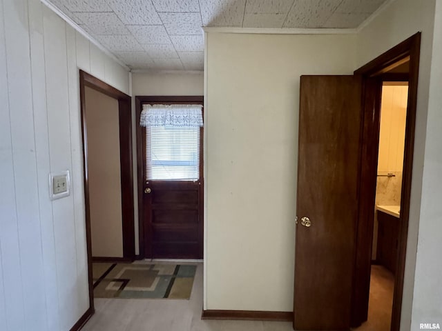 doorway to outside with wood walls and baseboards