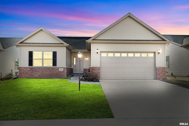 view of front of property with a garage, a lawn, concrete driveway, and brick siding