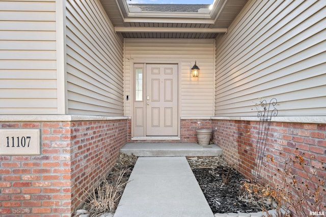 entrance to property featuring brick siding