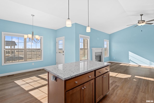 kitchen with baseboards, lofted ceiling, open floor plan, dark wood-style flooring, and a fireplace