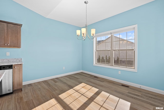 unfurnished dining area featuring a chandelier, visible vents, light wood finished floors, and baseboards