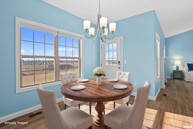 dining room with plenty of natural light, wood finished floors, visible vents, and baseboards