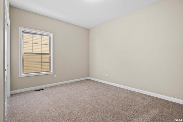 carpeted empty room with visible vents and baseboards