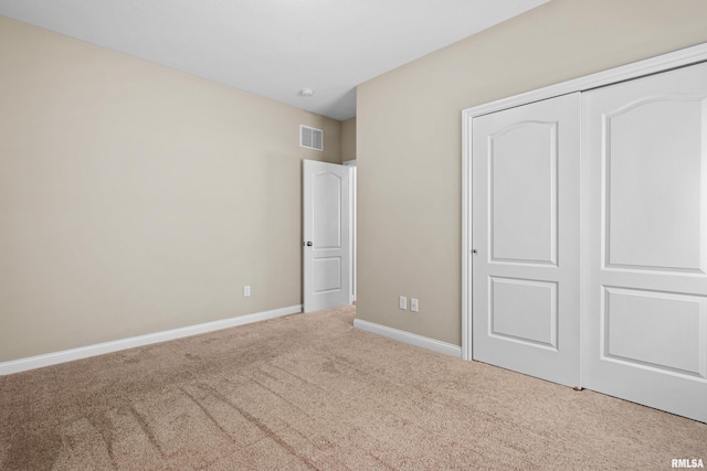 unfurnished bedroom featuring carpet floors, a closet, visible vents, and baseboards