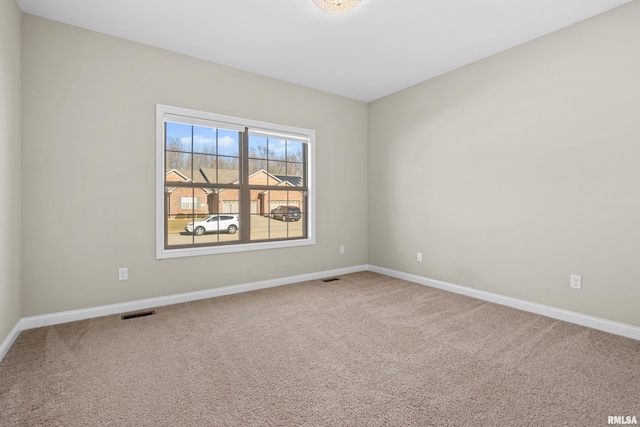 carpeted empty room with visible vents and baseboards