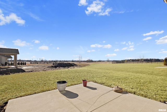 view of yard featuring a rural view, a patio, and fence