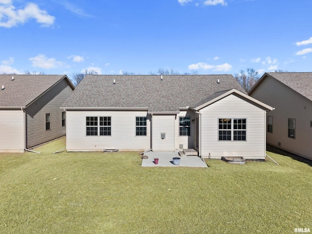 rear view of property featuring a patio area, roof with shingles, and a yard