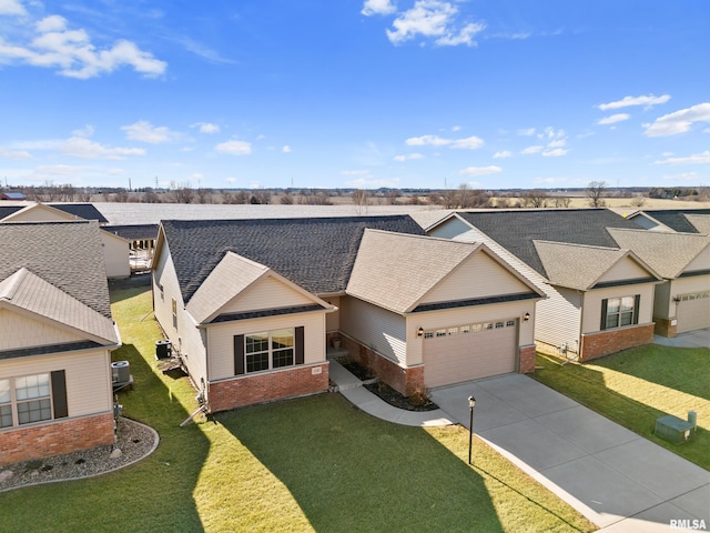 view of front of home featuring a garage, driveway, brick siding, and a front yard