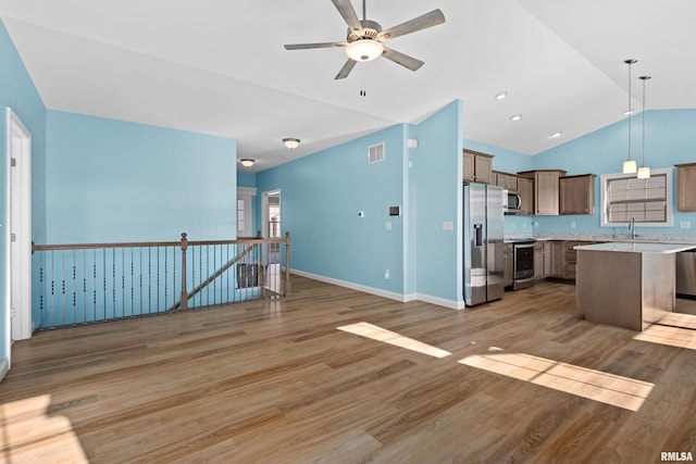 kitchen featuring visible vents, light wood-style flooring, appliances with stainless steel finishes, open floor plan, and a sink