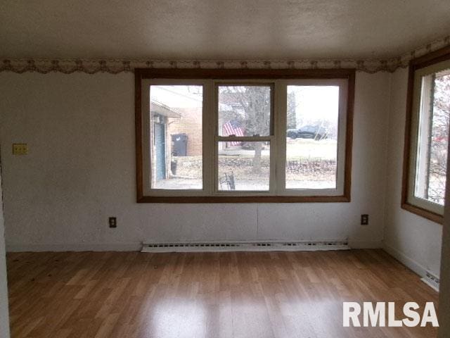 spare room featuring light wood finished floors and a baseboard radiator