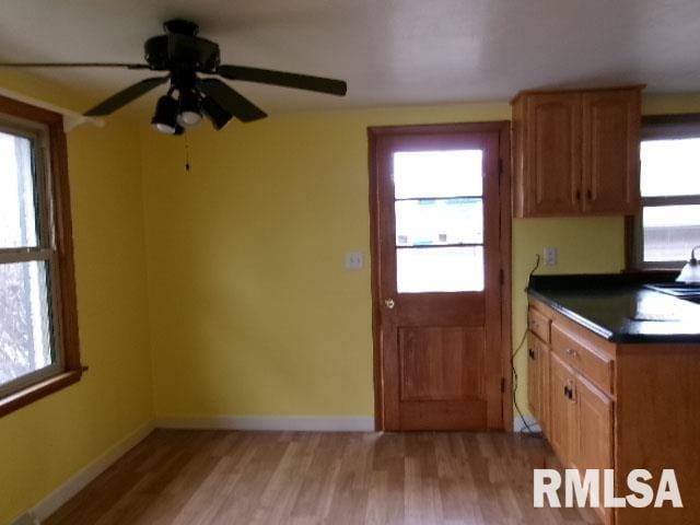 kitchen with dark countertops, light wood finished floors, and baseboards